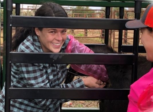 Ragan McFall, manager of the McFall Farm cow herd, being instructed on artificial insemination by Courtnie Carter.